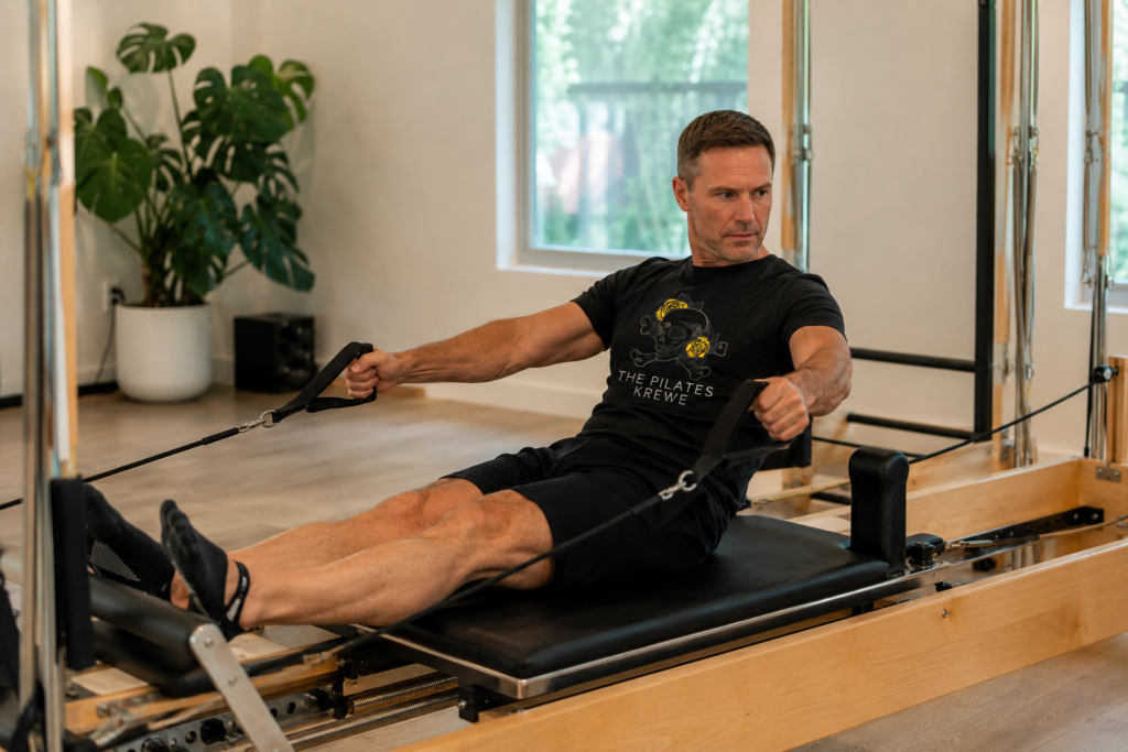 Photo of a man, over the age of 40, doing classical reformer Pilates